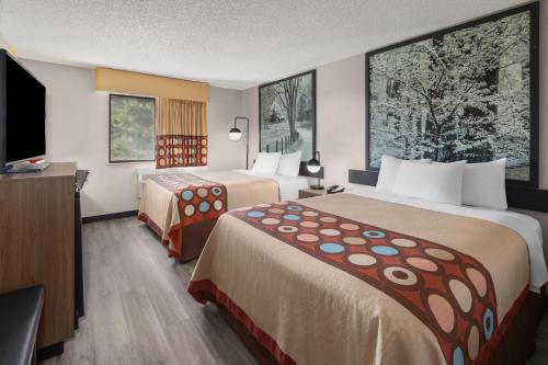 a hotel room with two beds and a flat screen tv at Super 8 by Wyndham Kent/Akron Area in Kent