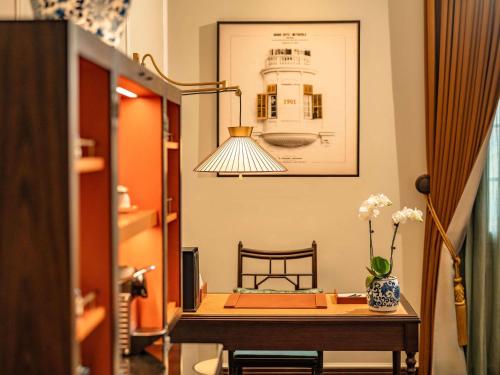 una stanza con un tavolo con un vaso di fiori sopra di Sofitel Legend Metropole Hanoi a Hanoi