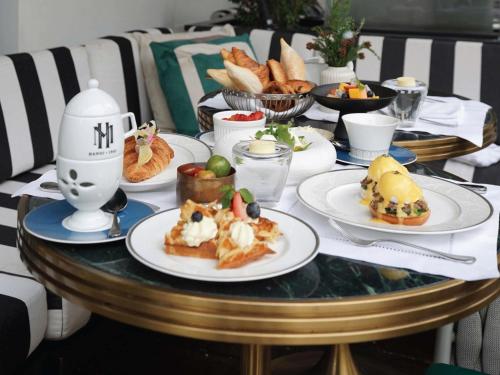 ein Tisch mit Tellern voller Essen darauf in der Unterkunft Sofitel Legend Metropole Hanoi in Hanoi