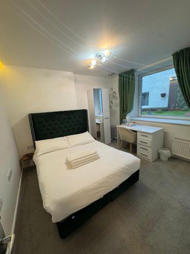 een slaapkamer met een bed, een bureau en een raam bij Dancenter Tolcarne Beach hotel in Newquay