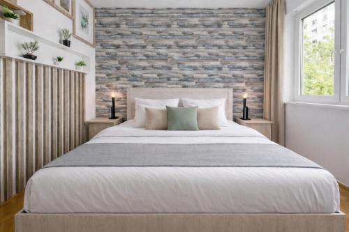 una camera da letto con un letto grande e un muro di mattoni di Comfort 14 Stylish City Apartment a Miskolc