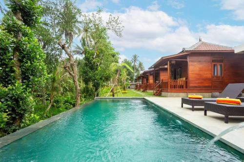 an infinity pool in front of a house at Pondok Naples Ubud in Ubud