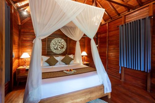 a bedroom with a bed with a canopy at Pondok Naples Ubud in Ubud