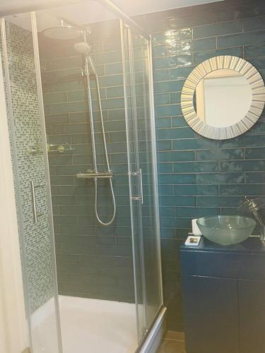 een badkamer met een douche met wastafel en spiegel bij Dancenter Tolcarne Beach hotel in Newquay