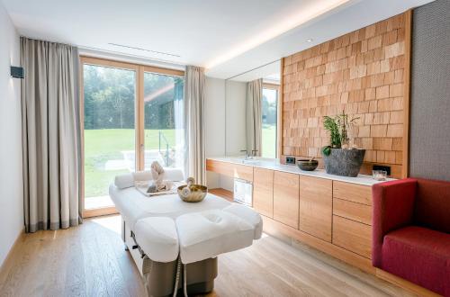 a living room with a white table and a red couch at Klosterhof – Alpine Hideaway & Spa in Bad Reichenhall