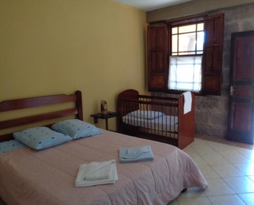 a bedroom with a bed with two towels on it at Pousada Fazenda Buracão in Mococa