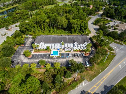 棕櫚海岸的住宿－Microtel Inn & Suites by Wyndham Palm Coast I-95，享有带停车场的大房子的空中景色