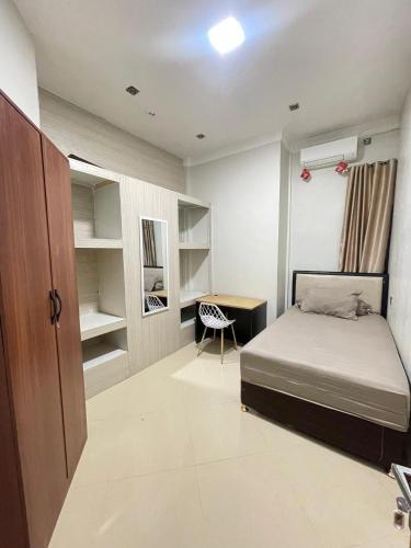 a small bedroom with a bed and a desk at Utama Guest House Kuta Alam in Banda Aceh