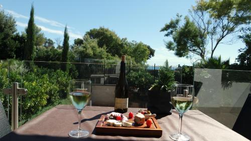a table with two glasses of wine and a bottle of wine at Villa Perle De La Mer in Saint-Aygulf