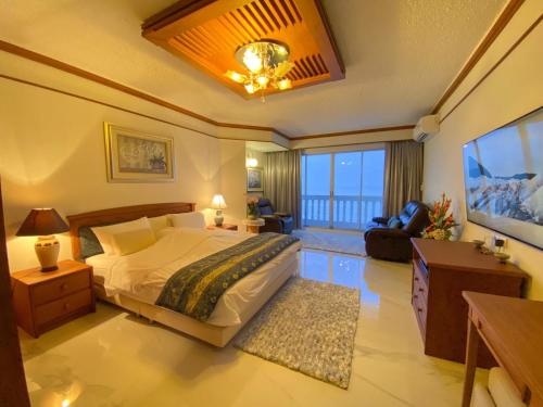 a bedroom with a large bed and a living room at Gamers Residence in Ban Nong Chaeng