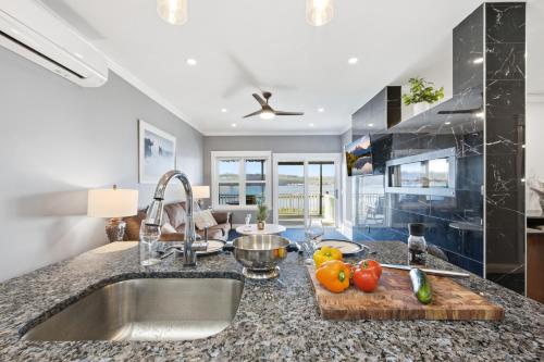 a kitchen with a sink and a cutting board with fruit on it at Riverside Retreat Waterfront Guest Suite in Groton