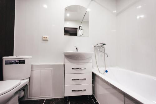 a white bathroom with a sink and a tub at Apartment 2Pillows Vorovskogo in Vologda