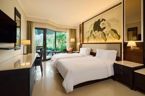 een hotelkamer met een groot bed en een televisie bij Dusit Thani Laguna Phuket in Bang Tao Beach