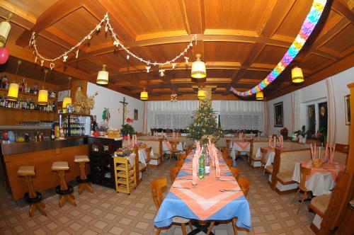 a restaurant with tables and a christmas tree in the middle at Pension Resy in Auna di Sopra