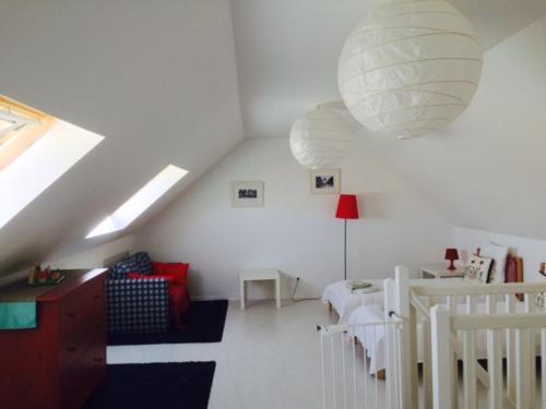 una sala de estar blanca con una gran lámpara de araña en Le Clos Surcouf, en Isigny-sur-Mer