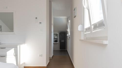 ein Flur mit weißen Wänden und Holzböden und ein Zimmer in der Unterkunft Villa Anteo-Split by Villas Guide in Košute