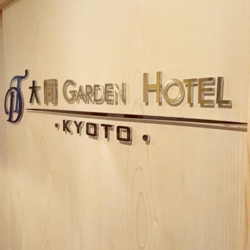 a sign for a garden hotel on a wall at 大同ガーデンホテル京都 in Kyoto