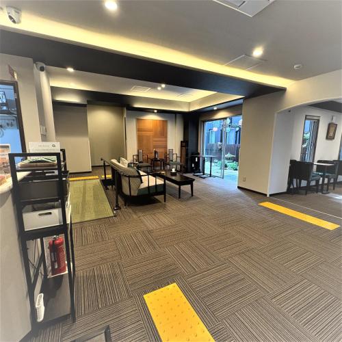 an empty lobby with tables and chairs in a building at 大同ガーデンホテル京都 in Kyoto