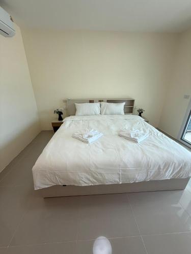 een slaapkamer met een groot bed met witte lakens bij Three Monkeys Chaweng Beach in Nathon Bay