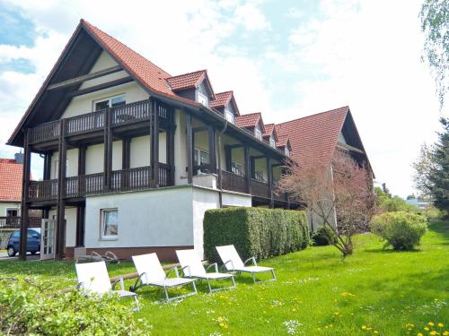 a group of white chairs in front of a house at Eisenberger Hof in Moritzburg