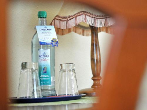 a bottle of water and two glasses on a shelf at Eisenberger Hof in Moritzburg