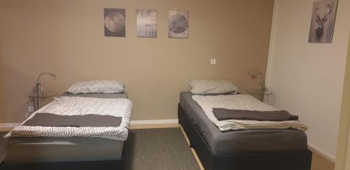 twee bedden in een kamer met foto's aan de muur bij Weitblick in Wadgassen