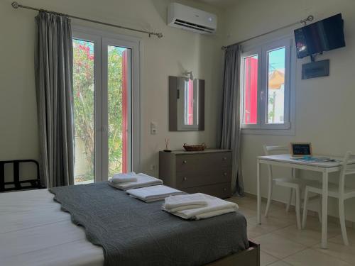 een slaapkamer met een bed, een tafel en ramen bij Solid Residence in Triovasálos