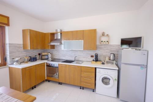 a kitchen with wooden cabinets and a white refrigerator at Tree home in Salerno Airport - Aeroporto di Salerno