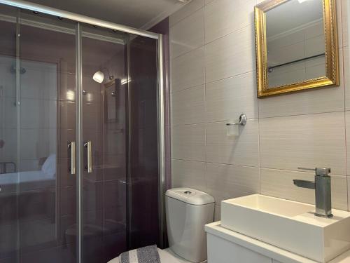 een badkamer met een douche, een toilet en een wastafel bij Solid Residence in Triovasálos