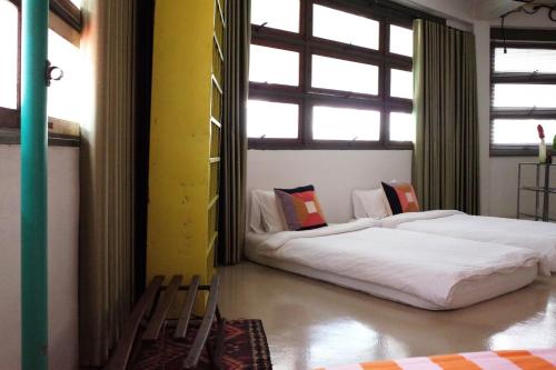 twee bedden in een kamer met twee ramen bij The Urbanists BKK Entire Floor 4-6 people 4Beds 4Baths near Medpark Hospital , Queen Sirikit Convention hall , Benjakitti Park in Bangkok