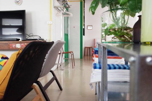 a room with a table and chairs and a glass table at The Urbanists BKK Best for groups & long stay near Medpark Hospital , Queen Sirikit Convention hall , Benjakitti Park in Bangkok