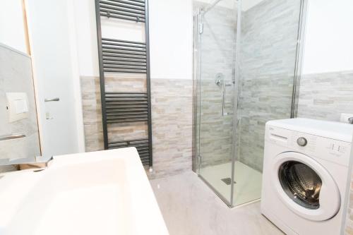 a white washing machine in a bathroom with a shower at Casa Roncalli in Foligno