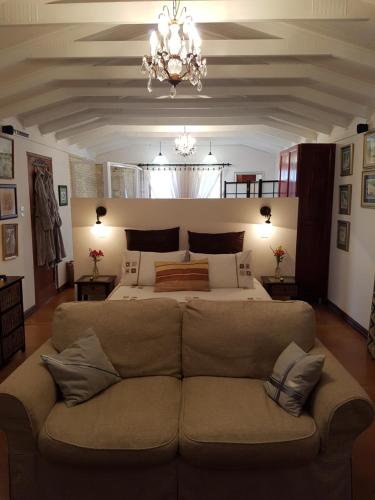 a bedroom with a large couch in front of a bed at Art Gallery Guest House in Haenertsburg