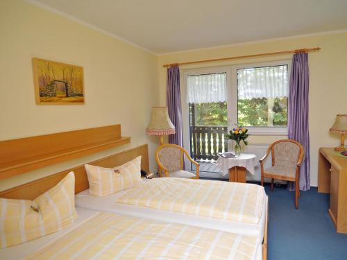 Habitación de hotel con cama, mesa y sillas en Eisenberger Hof, en Moritzburg