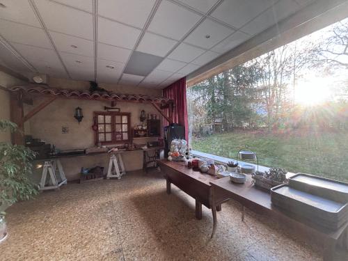 een woonkamer met een tafel en een groot raam bij Logis Hôtels La Crémaillère in Saint-Bonnet-en-Champsaur