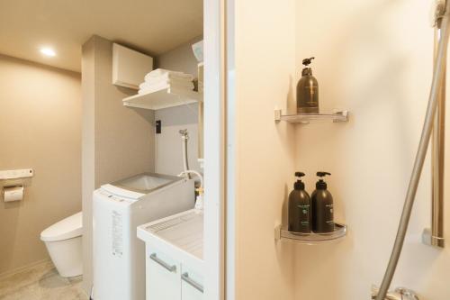 a bathroom with a toilet and bottles on the wall at 寅ホテル 蒲田 TORA HOTEL Kamata in Tokyo