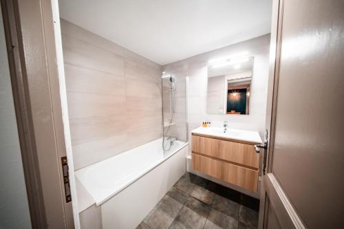 a bathroom with a tub and a sink and a bath tub at Le Refuge d'Elyze in Arc 1950