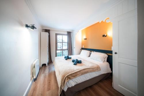 a bedroom with a bed with two blue teddy bears on it at Le Refuge d'Elyze in Arc 1950