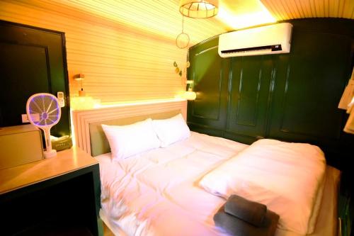 een slaapkamer met een wit bed, een bureau en een ventilator bij Baan Rot Fai Krabi Platform 2 in Ao Nam Mao