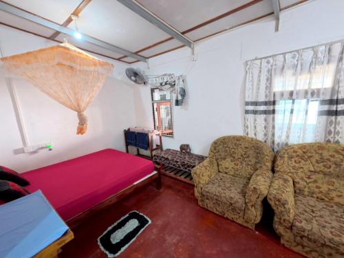een woonkamer met een bank en een stoel bij Little House Inn Anuradhapura in Anuradhapura