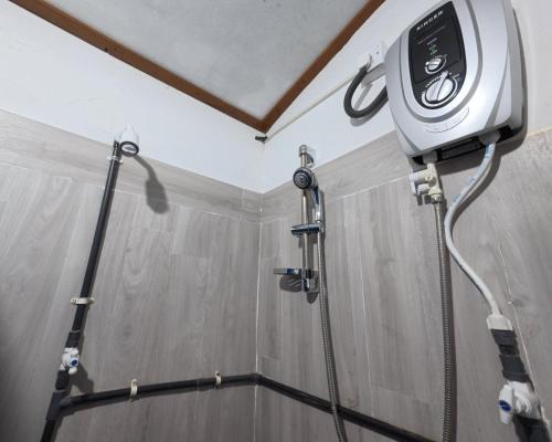 een douche in een badkamer met een douchekop bij Little House Inn Anuradhapura in Anuradhapura
