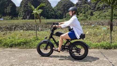 een vrouw rijdt op een motorfiets op de weg bij Heartfelt Hideaway 2 in Ninh Binh