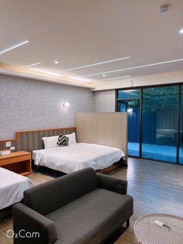 a hotel room with two beds and a couch at 夏日微醺二館 in Hengchun South Gate