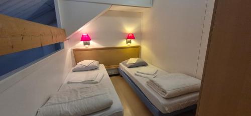 2 Betten in einem kleinen Zimmer mit 2 Lampen in der Unterkunft Village Montanha Lioran in Saint-Jacques-des-Blats