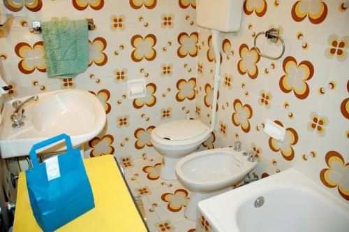 ein Bad mit einem WC und einem Waschbecken in der Unterkunft Appartamenti Meridiana in Lignano Sabbiadoro