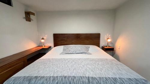 a bedroom with a large bed with two lamps on both sides at Casa Margarita in Pátzcuaro