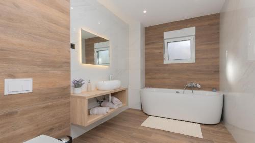 un bagno con una vasca bianca e un lavandino di Villa Lea-Makarska by Villas Guide a Grubine