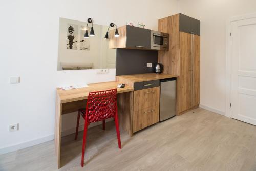 a kitchen with a wooden desk and a red chair at Partner Guest House Khreschatyk in Kyiv
