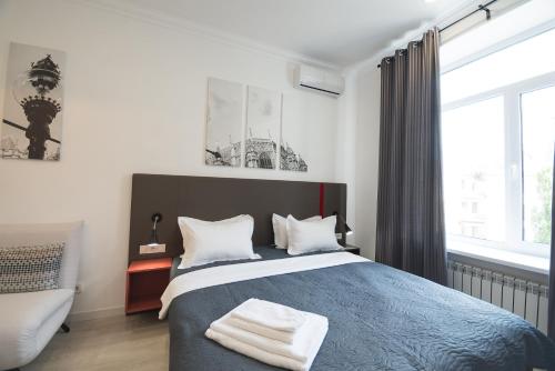 a bedroom with a blue bed and a window at Partner Guest House Khreschatyk in Kyiv