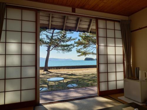 a room with a window with a view of the ocean at 直島町ふるさと海の家 つつじ荘 Seaside Stay Tsutsuji-so in Naoshima